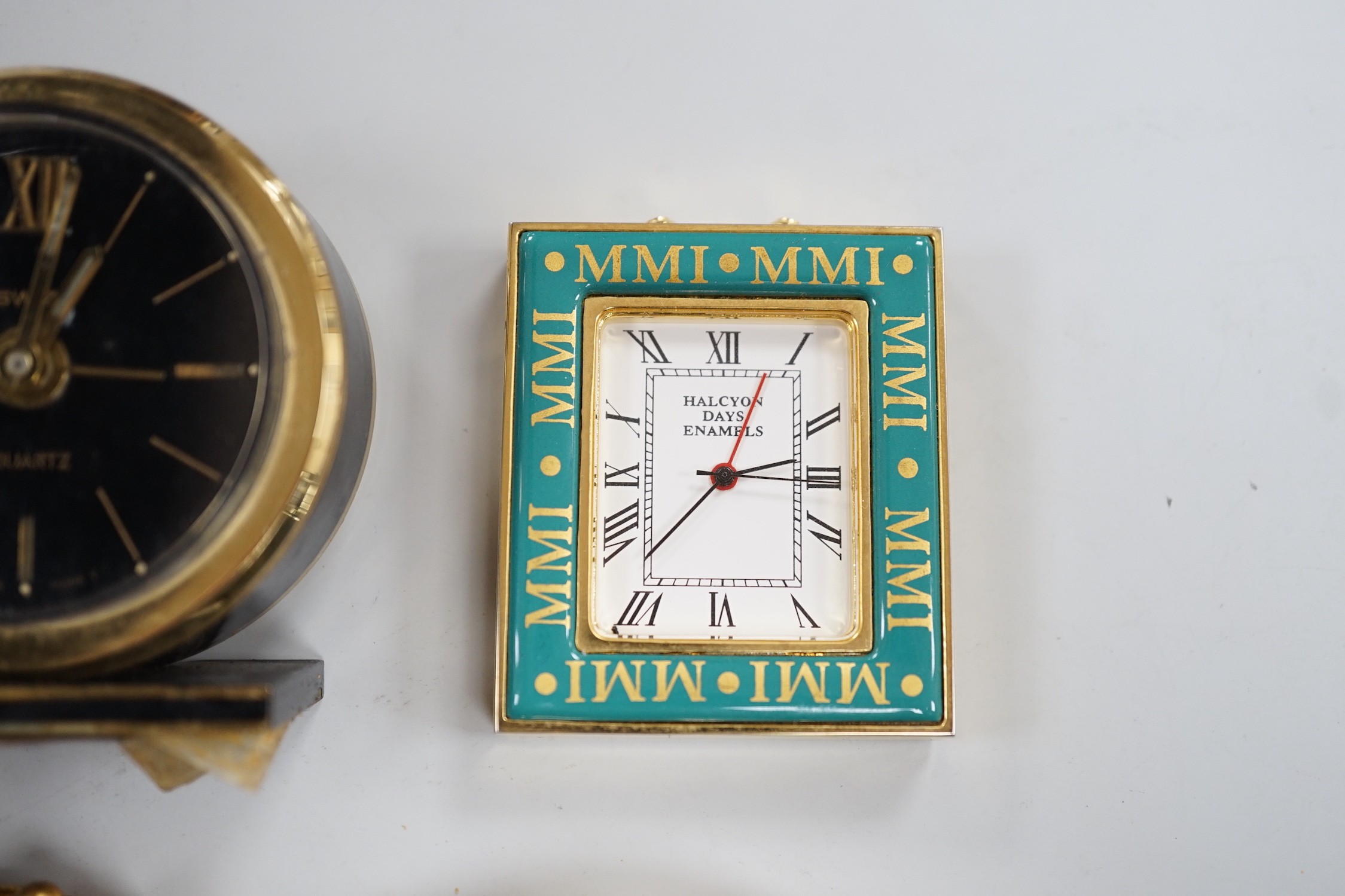 A Halcyon Days Harrods paperweight, a Halcyon Days timepiece and three other timepieces
